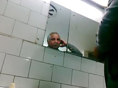 Oudere man laat zich aftrekken en pijpen in openbaar toilet